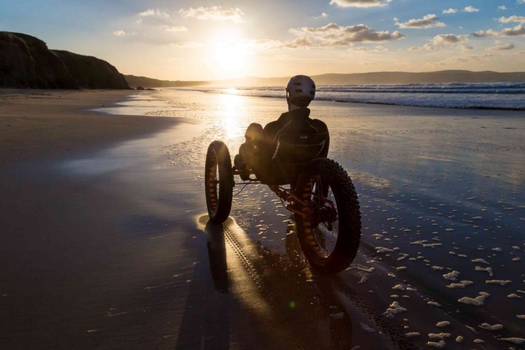 ICE Full Fat recumbent trike on a beach in the sunset