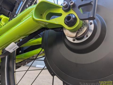 Closeup of Neodrive torque-arm holding wiring harness in place while engaging with the frame.